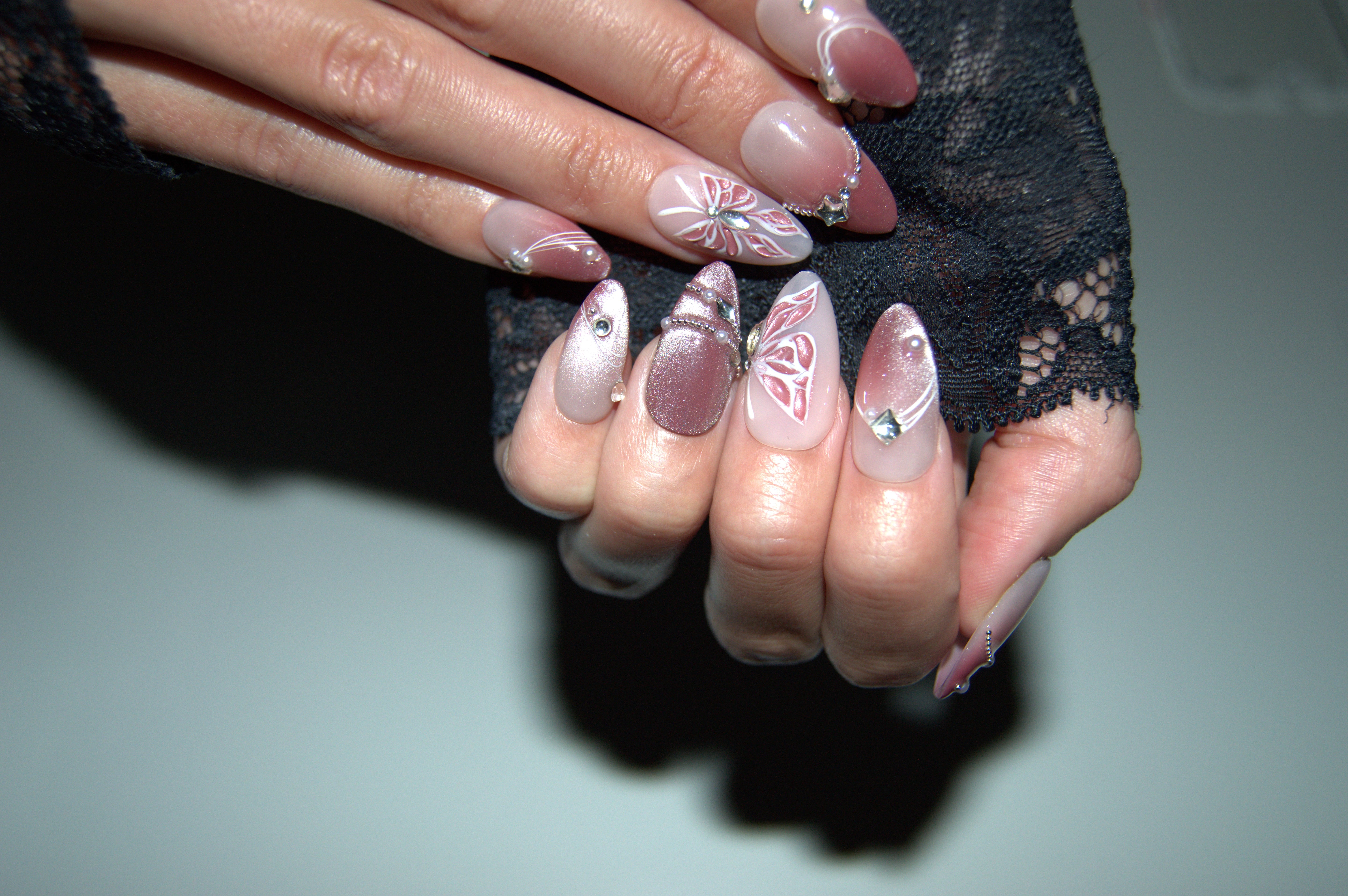 Ongles press-on Butterfly portés, faits main en gel et acrylique, nail art papillon rose, strass et dégradé brillant.