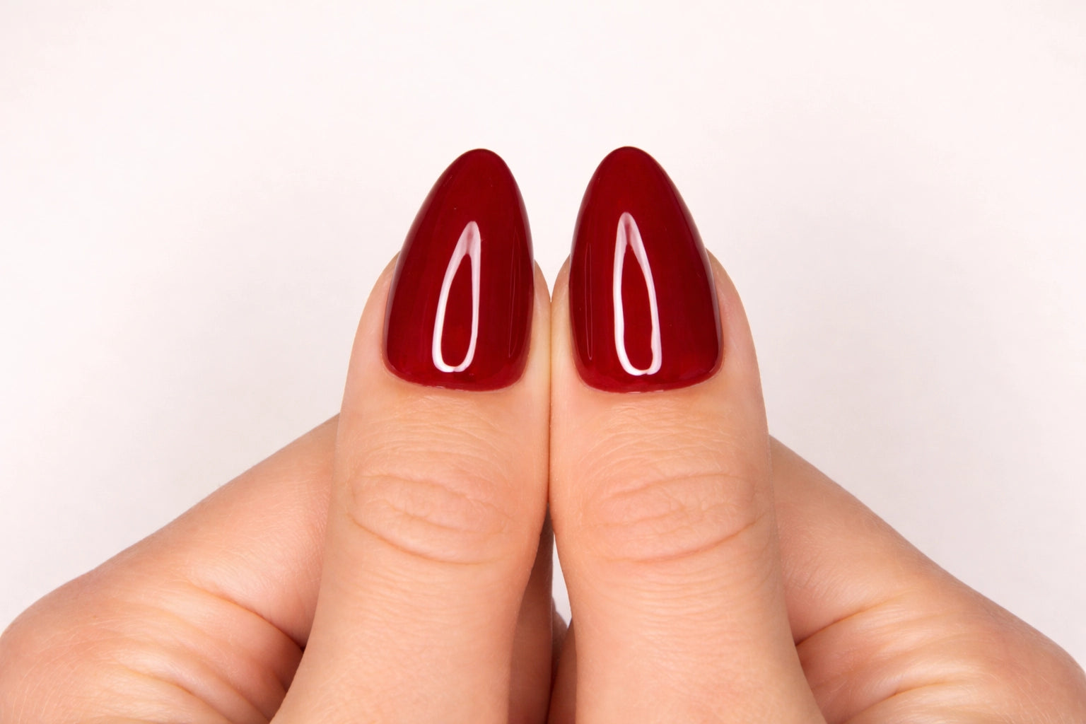 Gros plan sur le pouce avec faux ongle press-on bordeaux cerise brillant — design Plaid fait main — Mimi Press-On
