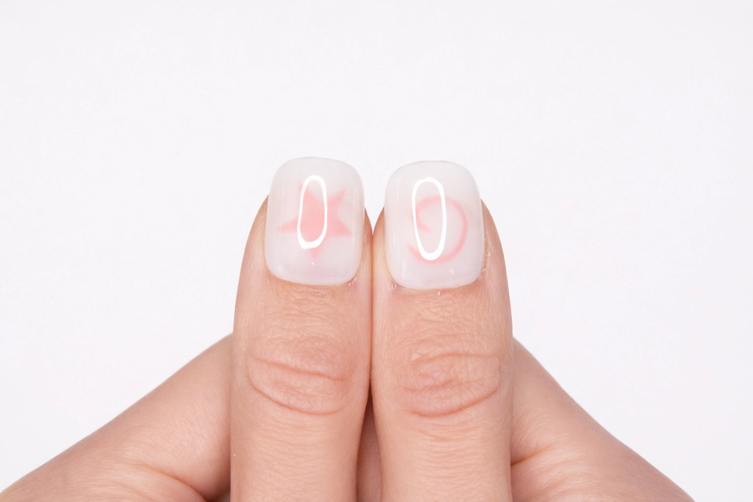 Gros plan sur le pouce avec faux ongle press-on blanc motif étoile rose — design Pink Dream fait main — Mimi Press-On