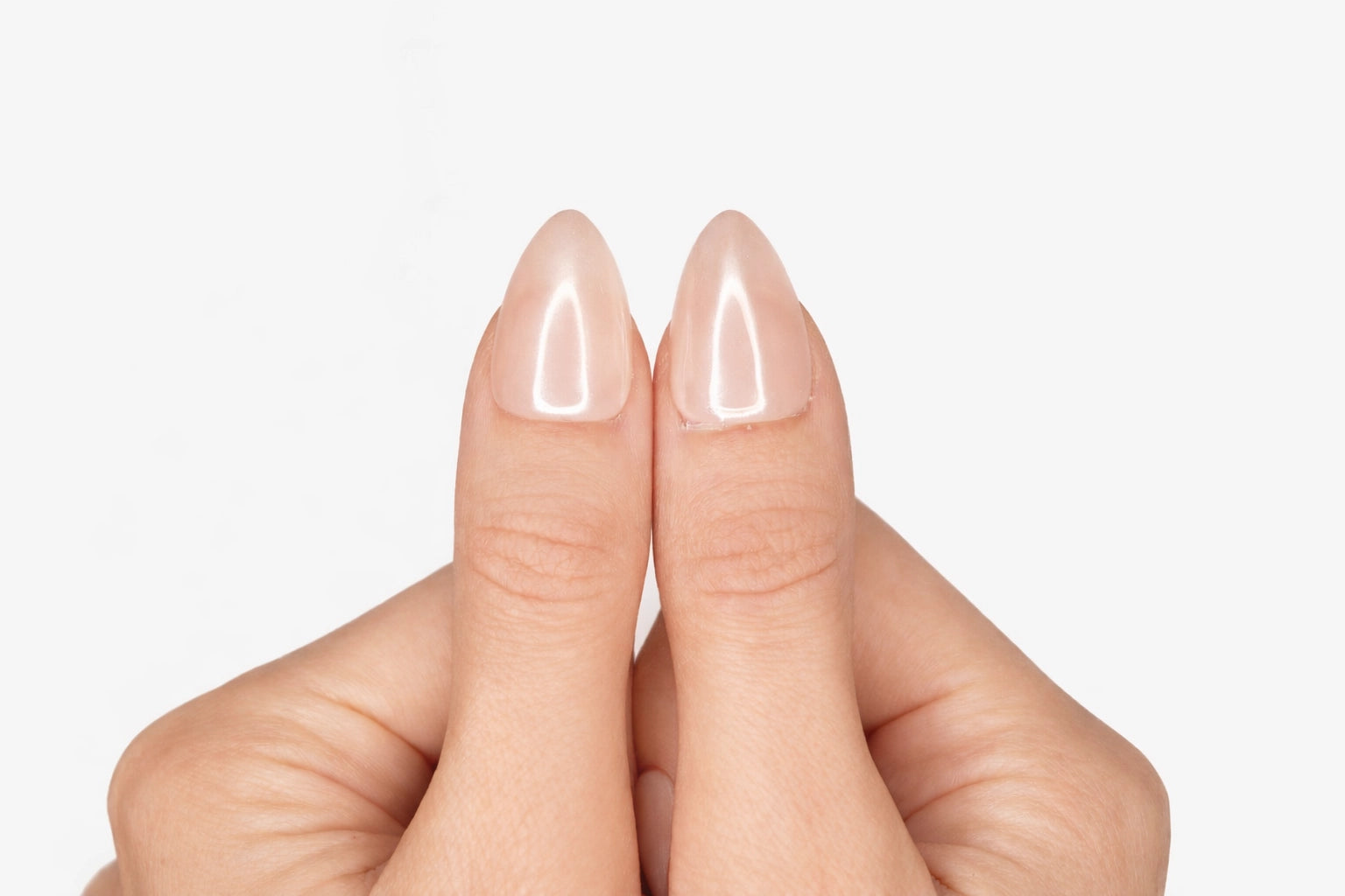 Gros plan sur le pouce avec faux ongle press-on rose pâle nacré effet glazed — design Hailey fait main — Mimi Press-On