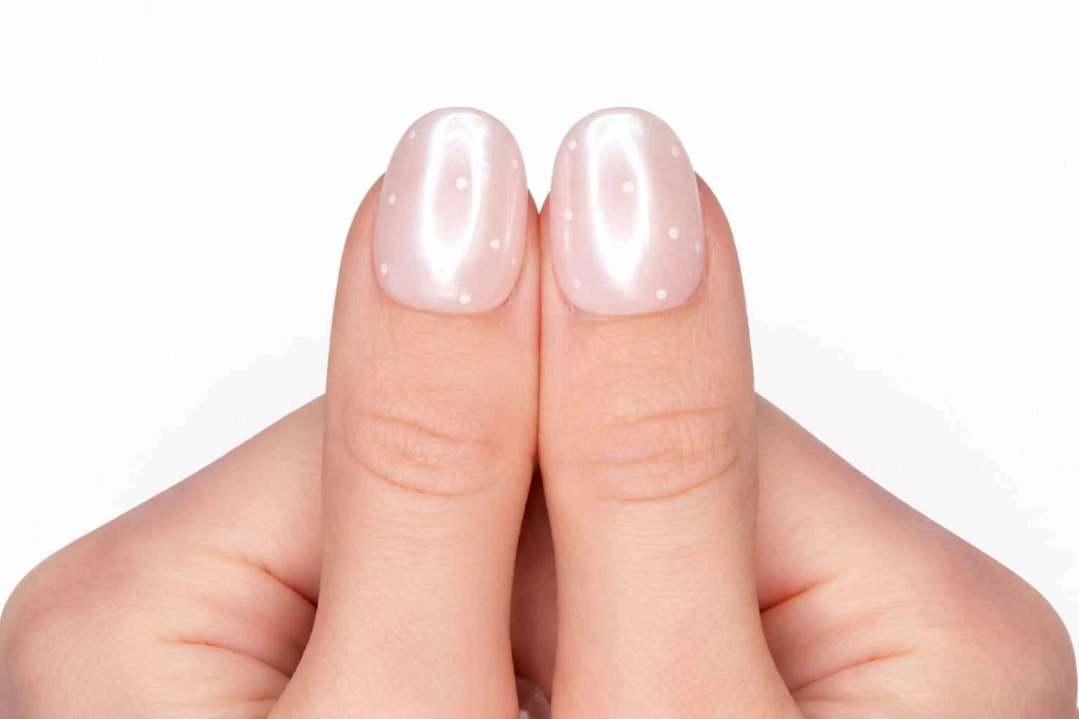 Gros plan sur le pouce avec faux ongle press-on rose poudré à pois blancs — design Hailey Dots fait main — Mimi Press-On