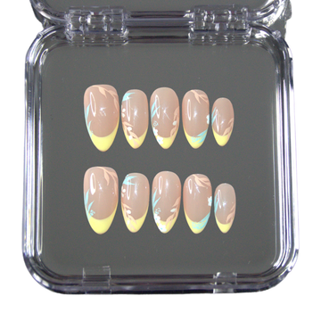 Set de faux ongles press-on faits main Secret Garden dans une boîte transparente, avec french jaune pastel et motifs floraux délicats.