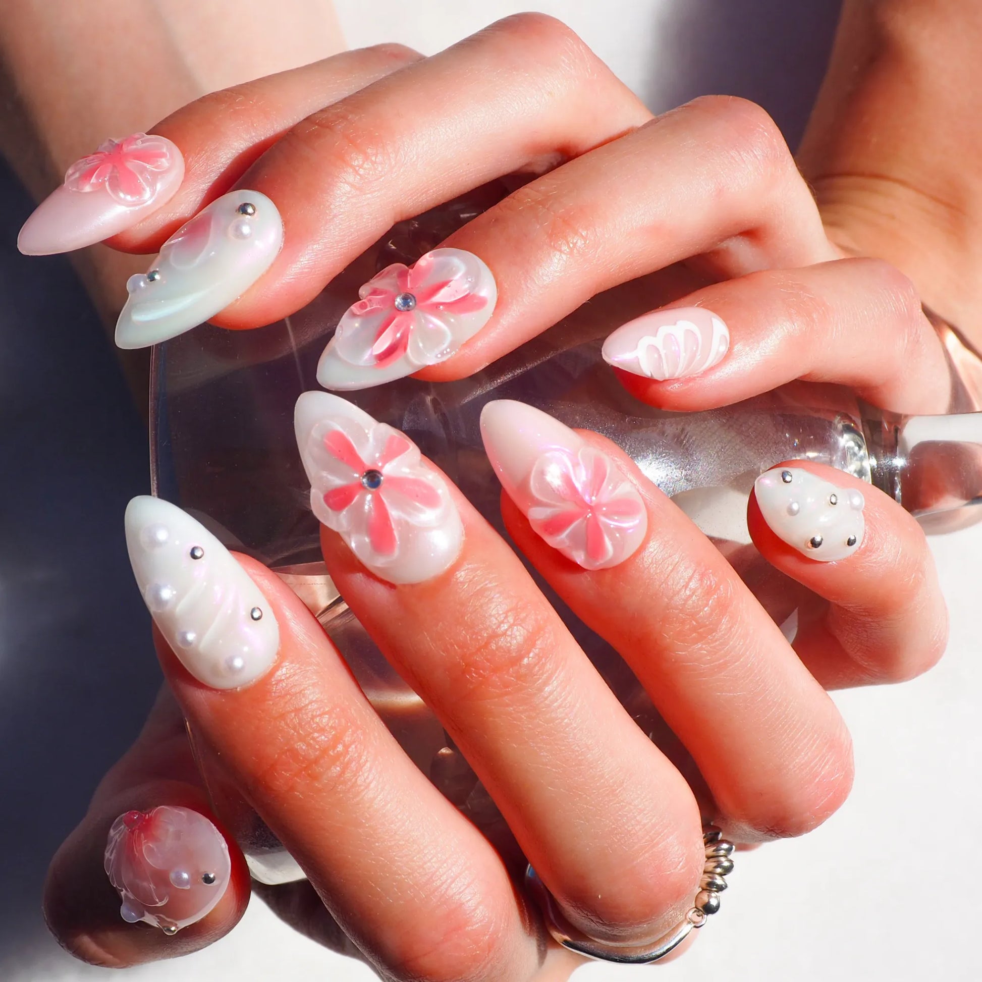 Set complet de press-on nails Pink Fever en gel et acrylique, décor floral 3D rose et blanc avec détails métalliques.