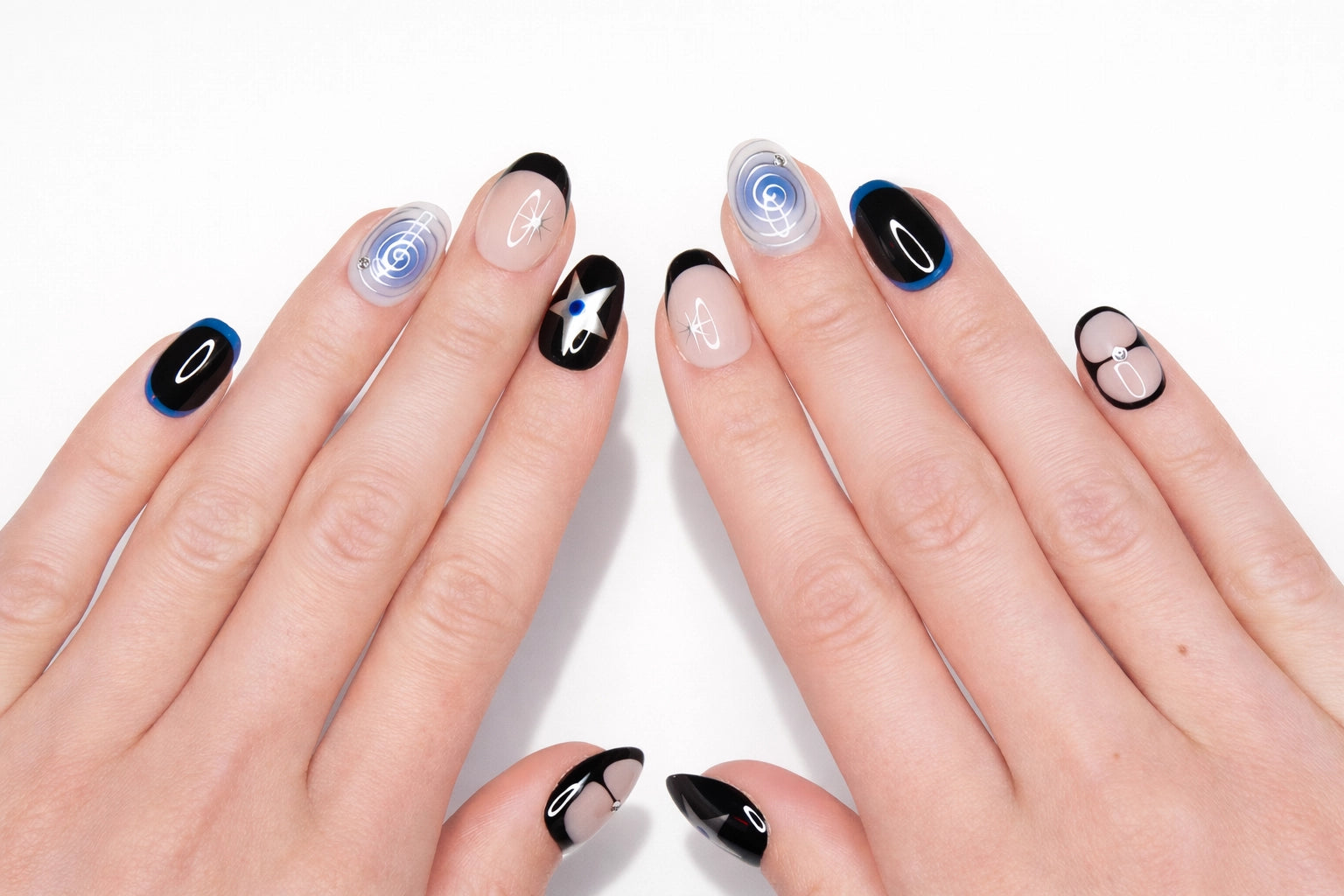 Faux ongles press-on Blue Orbit portés sur la main — étoiles argentées sur fond noir et spirale bleu ciel — Mimi Press-On