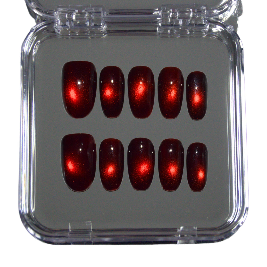 Vue du set complet de press-on nails faits main en gel et acrylique, effet cat eye rouge avec point lumineux central.