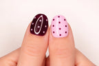 Gros plan sur le pouce avec faux ongle press-on bordeaux à pois blancs — design Berry Star fait main — Mimi Press-On