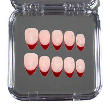 Set Holly Ruby dans sa boîte Mimi, press-on nails nude à french rouge décorée de perles, présentation produit.