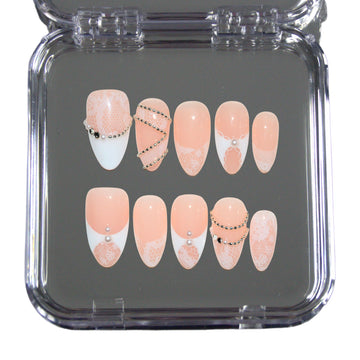 Set White Lace dans sa boîte, press-on nails faits main nude et french blanc dentelle avec détails perlés, présentation packshot.