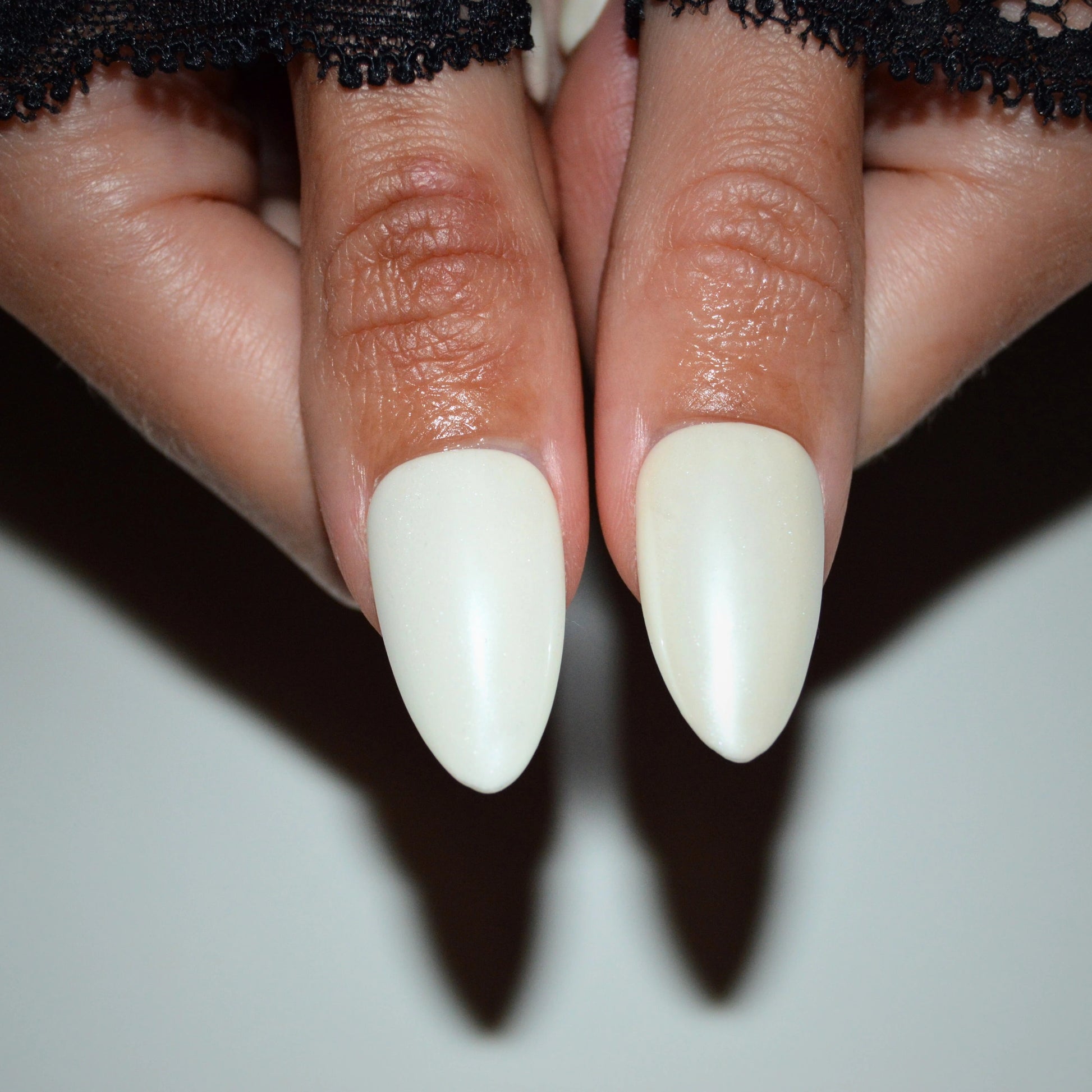 Press-on nails Winter Glaze portés, ongles blancs nacrés en forme amande, vue rapprochée du rendu Mimi France.